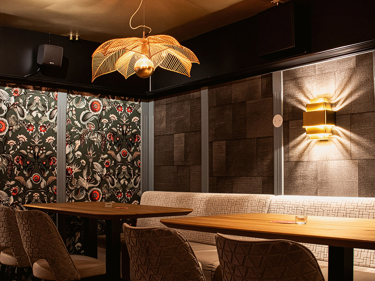 Stijlvol verlichte zithoek in Het Wapen van Rhoon met gouden wandlamp en opvallende hanglamp, geleverd door Straluma.