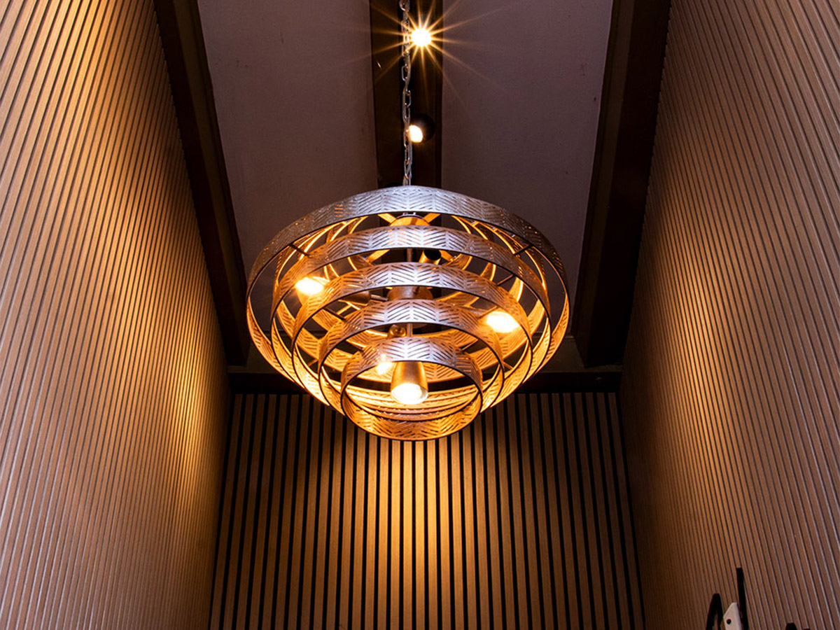 Grote moderne hanglamp van Straluma in een hoge houten gang bij Het Wapen van Rhoon.