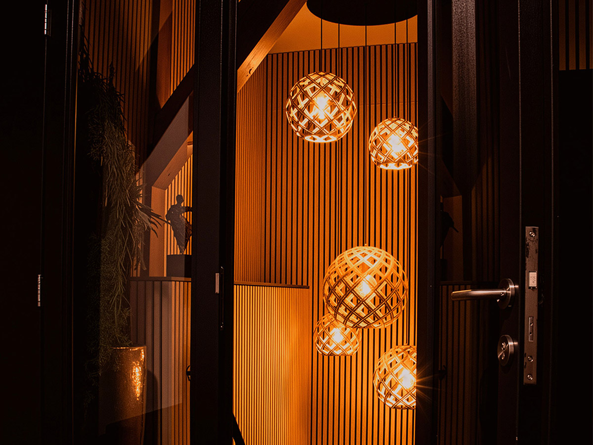 Cluster van warme hanglampen met opengewerkte bollen in entree van Het Wapen van Rhoon, geleverd door Straluma.