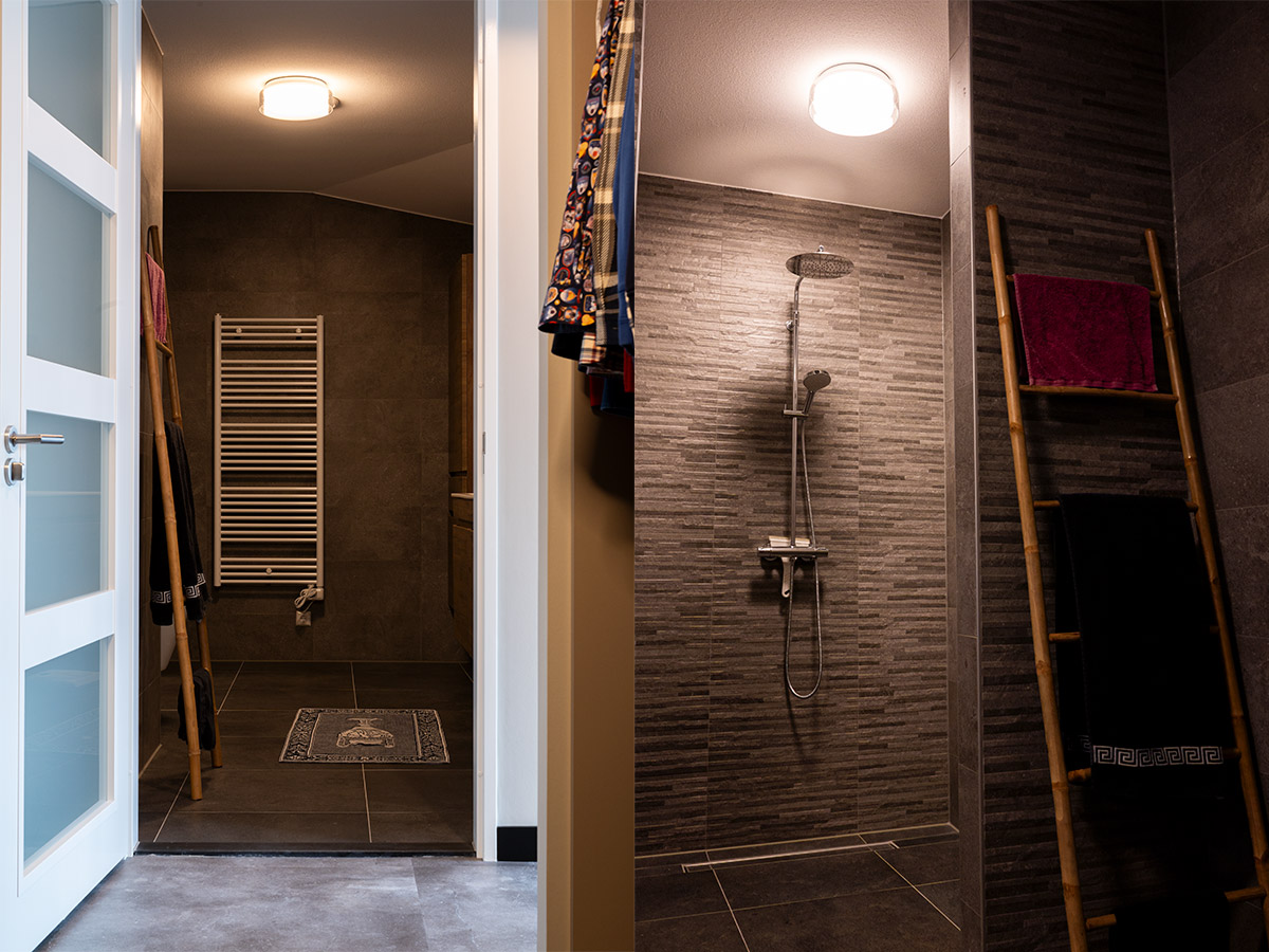 Badkamer en inloopkast met plafondverlichting en warme verlichting in modern penthouse