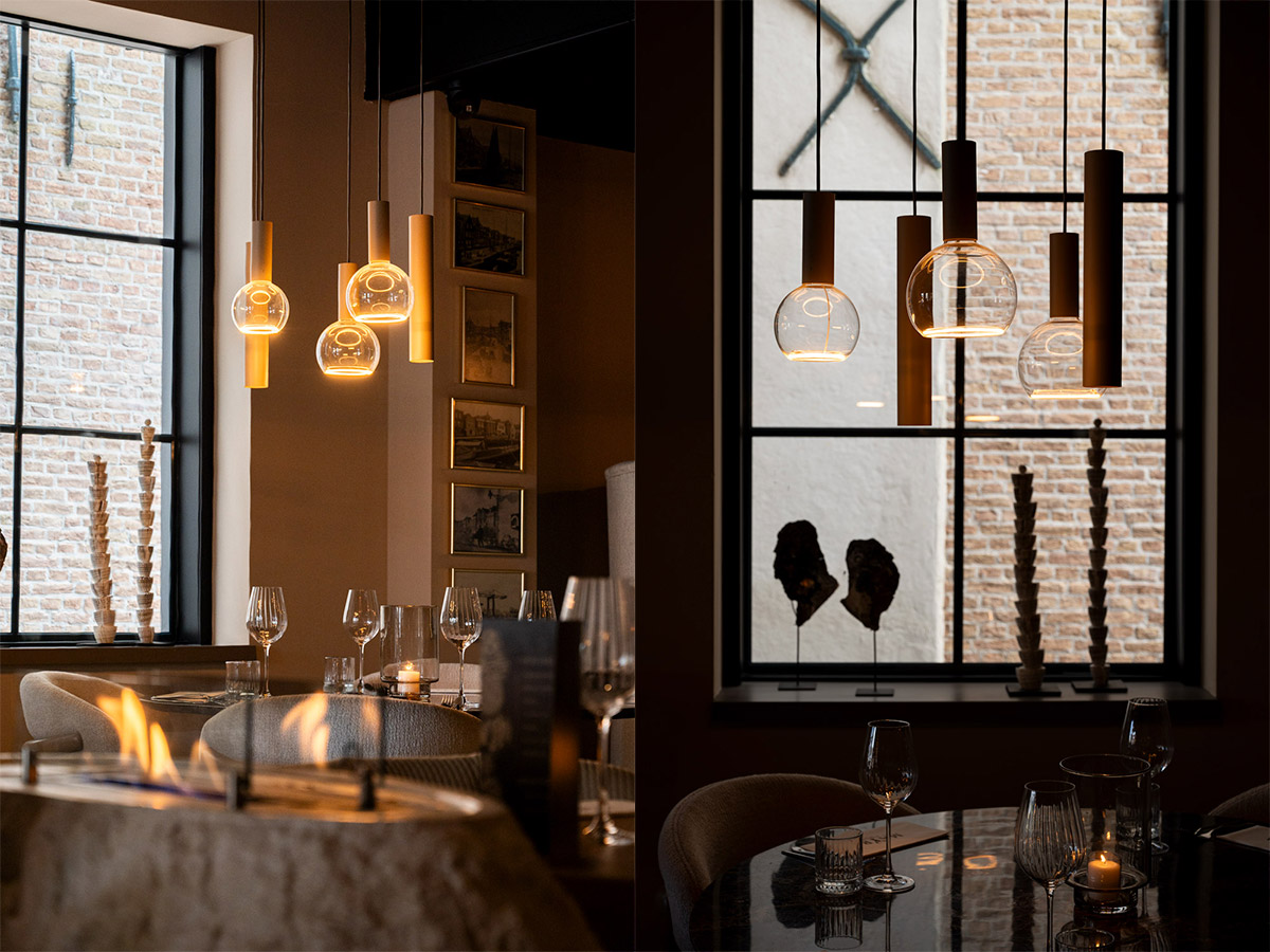 Design hanglampen met glazen kappen boven restauranttafels in een sfeervol horecainterieur